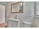 Bright full bathroom with white walls, tile, modern sink, with wood trimmed mirror at 707 E Calhoun St, Plant City, FL 33563