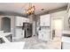 Spacious kitchen with white cabinetry, stainless steel refrigerator, and stylish lighting at 7214 Yardley Way, Tampa, FL 33647