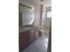 Cozy bathroom featuring a single sink vanity, tiled floors and shower, and natural light at 7279 Maidencane Ct, Seminole, FL 33777