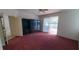 Bedroom with red carpet, sliding glass door to patio and backyard at 7279 Maidencane Ct, Seminole, FL 33777