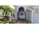 Close up of the front door of the house with a tiled walkway and landscaping at 7279 Maidencane Ct, Seminole, FL 33777