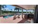 View of pool, brick patio, outdoor kitchen and landscaping, with fencing in the background at 7279 Maidencane Ct, Seminole, FL 33777