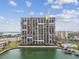 High-rise condo building features numerous private balconies overlooking the canal, swimming pool, and surrounding community at 7300 Sun Island S Dr # 1705, South Pasadena, FL 33707