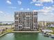 High-rise condo building features numerous private balconies overlooking the canal, swimming pool, and surrounding community at 7300 Sun Island S Dr # 1705, South Pasadena, FL 33707