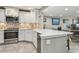 Modern kitchen with white cabinets, quartz countertops, stainless steel appliances, and a breakfast bar at 7300 Sun Island S Dr # 1705, South Pasadena, FL 33707