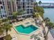 Beautiful view of the pool, spa and lounging area in this luxury waterfront condo with plenty of seating and lush landscaping at 7300 Sun Island S Dr # 1705, South Pasadena, FL 33707