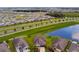 Aerial view of neighborhood with pond and lush landscaping at 8100 Olive Brook Dr, Wesley Chapel, FL 33545