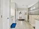 Bright bathroom hallway showcasing a walk-in shower, granite counters and a walk-in closet at the end of the hall at 8100 Olive Brook Dr, Wesley Chapel, FL 33545