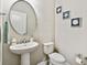Charming bathroom with a pedestal sink, an oval mirror and beach themed decorations at 8100 Olive Brook Dr, Wesley Chapel, FL 33545