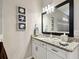 Charming bathroom with granite countertop vanity, decorative nautical themed art, and a large framed mirror at 8100 Olive Brook Dr, Wesley Chapel, FL 33545
