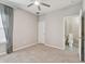 Spacious bedroom with a ceiling fan, neutral carpet, and an open doorway to the bathroom at 8100 Olive Brook Dr, Wesley Chapel, FL 33545