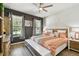 Bright bedroom with a ceiling fan, hard wood floors, a large window, and a gray accent wall at 8100 Olive Brook Dr, Wesley Chapel, FL 33545