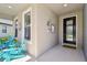 Inviting front porch with blue Adirondack chairs, decorative accents, and a welcoming front door at 8100 Olive Brook Dr, Wesley Chapel, FL 33545
