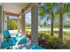 Cozy front porch with blue Adirondack chairs surrounded by tropical landscaping at 8100 Olive Brook Dr, Wesley Chapel, FL 33545