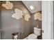 Cozy half bathroom with flower wall decals, a toilet, and a toilet paper holder and toilet paper at 8100 Olive Brook Dr, Wesley Chapel, FL 33545