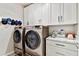 Well-organized laundry room featuring washer and dryer sets, cabinet storage, and countertop space at 8100 Olive Brook Dr, Wesley Chapel, FL 33545