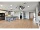 Open-concept living area with hardwood floors, ceiling fan, kitchen island, and seamless flow at 8100 Olive Brook Dr, Wesley Chapel, FL 33545