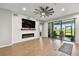 Living room boasts an electric fireplace, shiplap wall, large sliding doors to the lanai and wood floors at 8100 Olive Brook Dr, Wesley Chapel, FL 33545