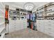 Spacious walk-in closet featuring custom shelving, drawers, and a stylish chandelier for ample storage at 8100 Olive Brook Dr, Wesley Chapel, FL 33545