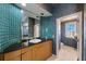 Bathroom featuring a single sink vanity with wood cabinets and green tiled walls at 816 Ponce De Leon Dr, Tierra Verde, FL 33715