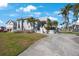 Elegant home showcasing a grand circular driveway, mature trees, and a beautifully landscaped lawn at 816 Ponce De Leon Dr, Tierra Verde, FL 33715