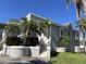 Attractive light grey exterior of a home with white trim, tiered landscaping, and tropical palms under a blue sky at 816 Ponce De Leon Dr, Tierra Verde, FL 33715
