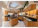 Bright kitchen featuring stainless steel appliances, granite countertops, island cooktop, and decorative overhead lighting at 816 Ponce De Leon Dr, Tierra Verde, FL 33715