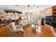 Spacious living room featuring hardwood floors, decorative plants, bright windows, and a kitchen bar at 816 Ponce De Leon Dr, Tierra Verde, FL 33715