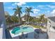 Aerial view of a backyard pool and spa surrounded by lush palm trees at 816 Ponce De Leon Dr, Tierra Verde, FL 33715