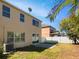 Exterior view of the home's backyard, showcasing the lawn and patio area with clear, sunny skies at 8314 Deerland Bluff Ln, Riverview, FL 33578