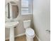 A half bath featuring a pedestal sink, an oval mirror, and a white toilet at 8314 Deerland Bluff Ln, Riverview, FL 33578