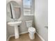 A half bath featuring a pedestal sink, an oval mirror, and a white toilet at 8314 Deerland Bluff Ln, Riverview, FL 33578