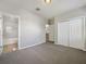 Bedroom with carpet flooring, ensuite bathroom, and closet with white bi-fold doors at 8314 Deerland Bluff Ln, Riverview, FL 33578