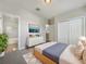 Bedroom with carpet flooring, ensuite bathroom, closet, and a television above the dresser at 8314 Deerland Bluff Ln, Riverview, FL 33578