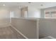 Bright, neutral hallway upstairs with a door, closet and railing overlooking the open concept living area at 8314 Deerland Bluff Ln, Riverview, FL 33578
