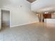 Spacious living room with light-colored tile flooring and an open layout leading to the kitchen and staircase at 8314 Deerland Bluff Ln, Riverview, FL 33578