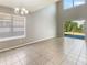 Bright living room with light gray walls, high ceilings, and a sliding glass door to the exterior at 8314 Deerland Bluff Ln, Riverview, FL 33578