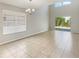 Bright living room featuring high ceilings, neutral paint and tile floors, leading to the patio at 8314 Deerland Bluff Ln, Riverview, FL 33578