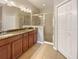 Bathroom featuring double sinks, granite countertops and a framed shower at 8314 Deerland Bluff Ln, Riverview, FL 33578