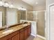 Bathroom featuring double sinks, a framed shower, and granite countertops at 8314 Deerland Bluff Ln, Riverview, FL 33578