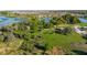 Expansive aerial view showing community waterways, green spaces, clubhouse, parking, and a well-maintained landscape at 9748 Ibis Grove Blvd, Wesley Chapel, FL 33545