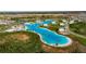 Breathtaking aerial view of a community's expansive lagoon with sandy beach, water park and amenities at 9748 Ibis Grove Blvd, Wesley Chapel, FL 33545