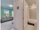 Bright bathroom featuring shower-tub combo and a neutral color scheme, seamlessly connected to a living space at 9748 Ibis Grove Blvd, Wesley Chapel, FL 33545