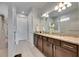 Bathroom featuring double vanity with granite counters and private shower at 9748 Ibis Grove Blvd, Wesley Chapel, FL 33545