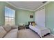 Bright bedroom featuring large window, closet and neutral-toned sofa at 9748 Ibis Grove Blvd, Wesley Chapel, FL 33545
