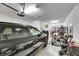 Organized garage featuring a vehicle and ample space for storage and home gym setup at 9748 Ibis Grove Blvd, Wesley Chapel, FL 33545