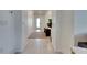 Inviting white hallway featuring neutral tile flooring and a clear view to the entryway at 9748 Ibis Grove Blvd, Wesley Chapel, FL 33545
