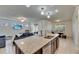 Open kitchen with granite island, stainless appliances, and view of the living room and dining area at 9748 Ibis Grove Blvd, Wesley Chapel, FL 33545