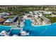 Stunning aerial view of the community's lagoon pool with cabanas, lounge chairs, and crystal-clear turquoise water at 9748 Ibis Grove Blvd, Wesley Chapel, FL 33545