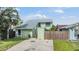 Charming two-story home with light green exterior, well-maintained landscaping, and a gray roof at 10306 Green Grove Pl, Tampa, FL 33624